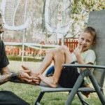 Playful interaction between a father and son in a sunny backyard setting.